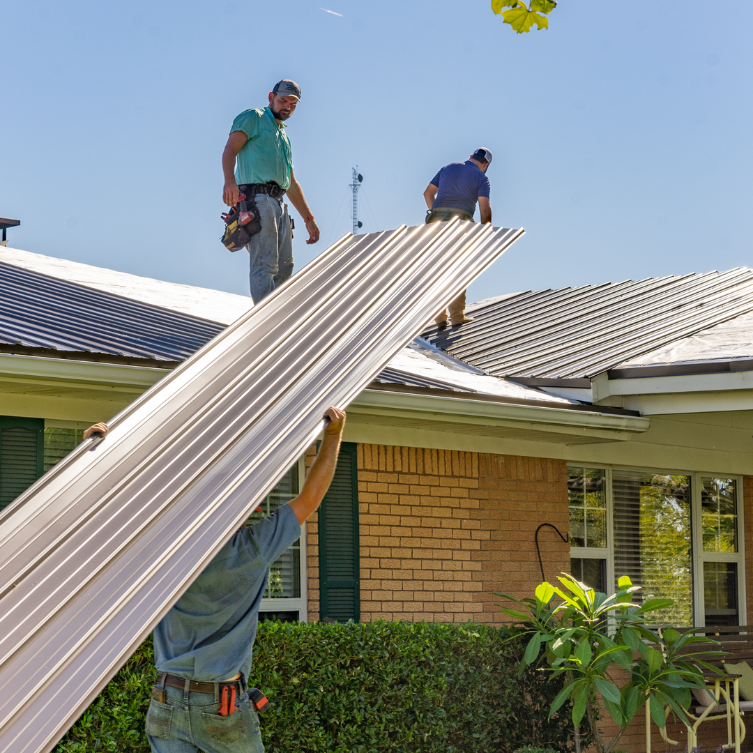 workers installing metal roof over shingles